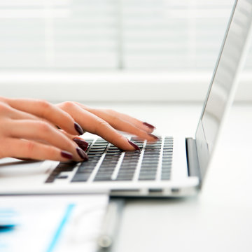 Closeup of businesswoman typing on laptop computer