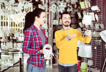 Obraz premium Smiling man and girl in lighter shop discussing purchase of night light