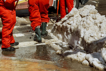 municipal urban servicing workers shoveling snow during winter road cleaning