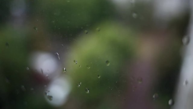 Close up of plastic glass of window with drops of rain and dust. Real time full hd video footage.