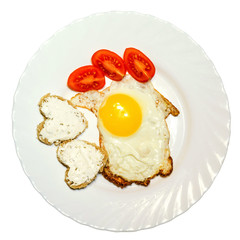 Sliced tomatoes, fried eggs and toast in the shape of heart on a plate top isolated on white background