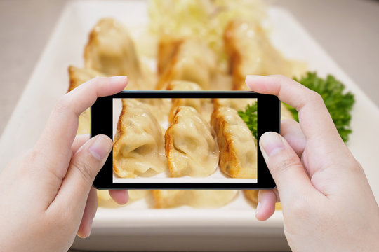 taking photo of Gyoza dumplings with smartphone