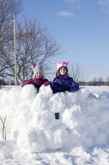 Girls standing in large snow fort