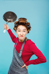 Girl jokes with frying pan in hands while making food