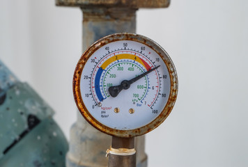 Closeup of manometer, measuring gas pressure. Pipes and valves at industrial plant.