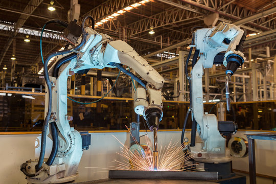 Team robots are test run welding in car factory