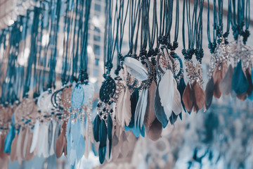 Necklace / Necklace made from feather on shelf in the store. Shallow depth of field. - 142370926