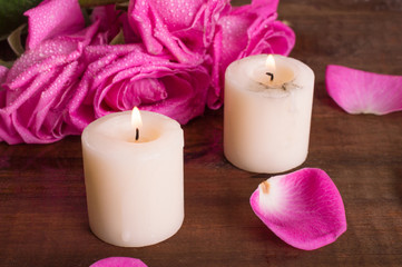 Fototapeta na wymiar Pink roses and candles on a bright background