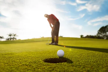  Senior man putting golf ball © Kathy images