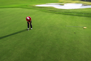 Senior man putting golf ball