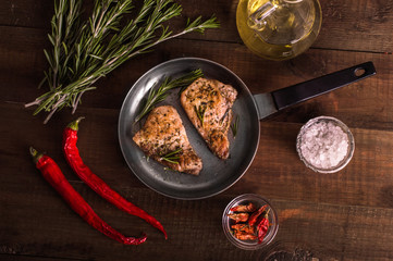 Fried meat and rosemary in a frying pan