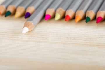 Naklejka premium set of different colored pencils on wooden desk