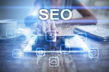 Woman using tablet pc, pressing on virtual screen and selecting seo.