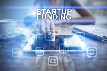 Woman using tablet pc, pressing on virtual screen and selecting startup funding.