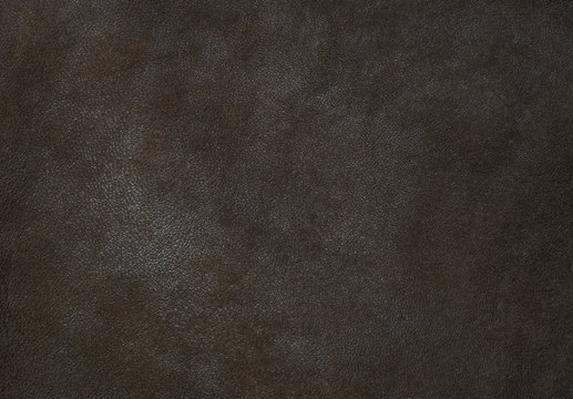 Dark brown leather texture close up can be used as background.