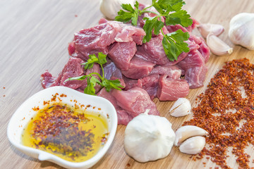 Raw meat, garlic and olive oil on wooden floor