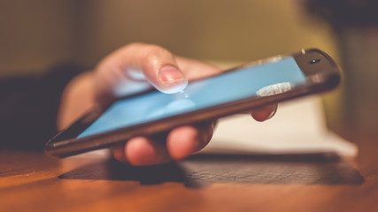 A woman's hand is playing a smartphone.