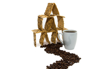 A cup of coffee next to the cookie house, the road from the grains of the coffee.