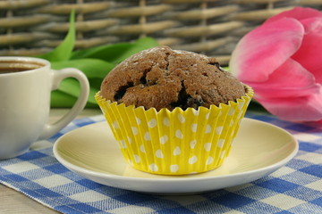 Chocolate muffins and flowers on the table