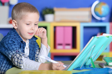 Boy with glasses and books making lessons