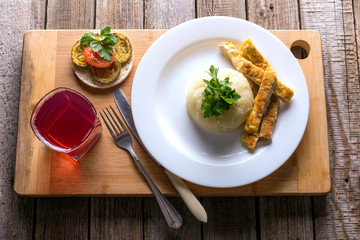  potato puree with minced steak on a wooden table, fruit compote in a glass