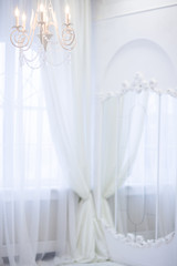 Classic chandelier at the creative white mirror background. Interior of wedding room