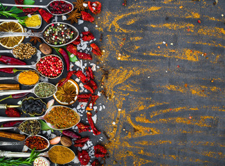 Various spices spoons on stone table. Top view .