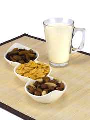 a glass of milk with dried fruits and flakes. 
