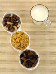 a glass of milk with dried fruits and flakes. 