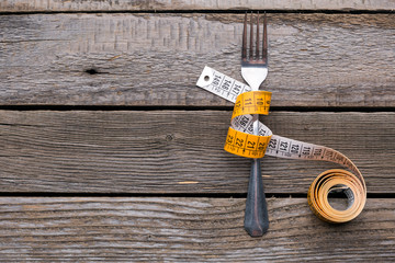 Measuring tape wrapped around fork. Diet concept