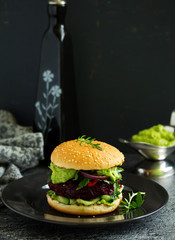Vegetarian vegetable burger with beetroot and guacamole sauce.