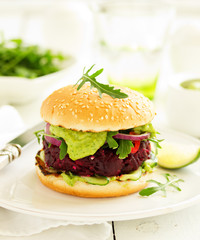 Vegetarian vegetable burger with beetroot and guacamole sauce.