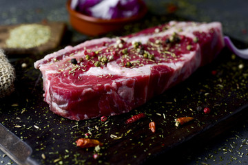 raw strip steak seasoned with different spices