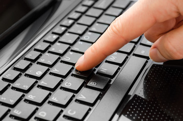 hand of girl typing on keyboard.