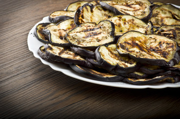 Fototapeta na wymiar Aubergines eggplants and slices grilled on the plate