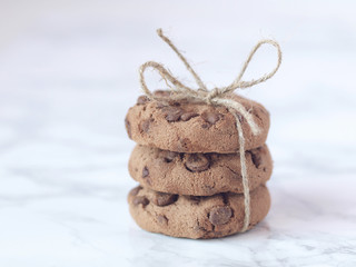 Crisp chocolate cookies wrapped with string on marble background