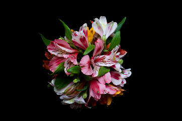 Bright bouquet on a black background, top view.
