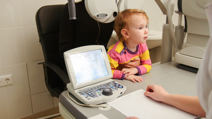 Child - little girl - patient in ophthalmologist room - child with mommy at the on consultation
