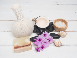Obraz na płótnie Canvas Aromatherapy product Spa set ,candle ,soap,coconut orchid flower,shell, massage with white wood background . top view composition.