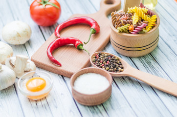 Still life with pasta ingredients on the wooden background