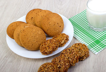 Glass of milk and cookies on wooden table 