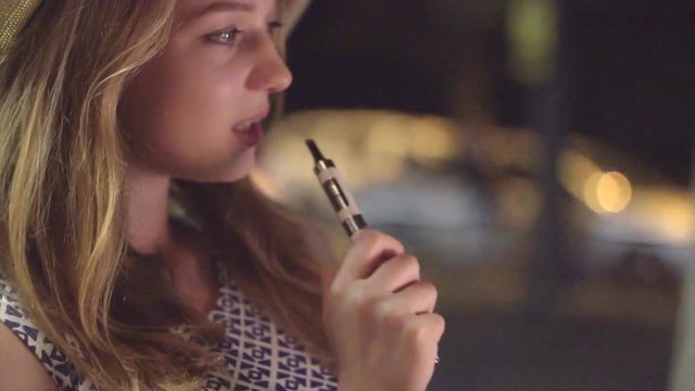 Young woman vaping e-cigarette. Smoking hipster girl. Slow motion 240 fps 4K. UHD video 3840X2160