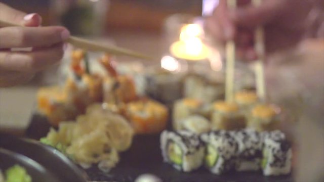 Couple eating sushi rolls in japan restaurant, sushi bar. Slow motion 240 fps 4K UHD video 3840X2160
