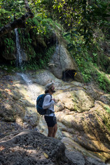 Man enjoying the waterfall and the jungle in Thailand