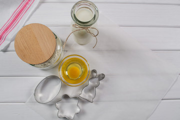 Preparation of gingerbread man cookies. Ingredients, cookie cutters  and kitchen tools on parchment paper