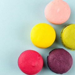 Colourful french macaroons on the blue background, Top view. Square