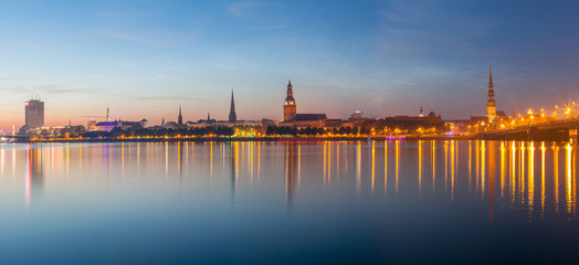 Fototapeta na wymiar Old Riga night skyline. Illuminated city after sunset. Panoramic view over Daugava river