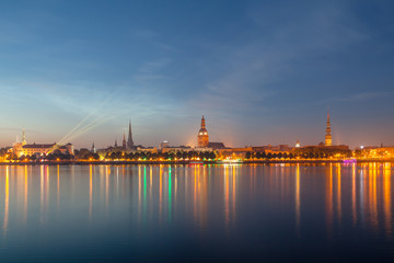 Old Riga night skyline. Illuminated city after sunset. Panoramic view over Daugava river