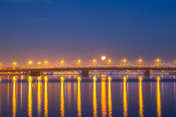 Daugava river and the railway bridge. Night panoramic scene in Riga, Latvia