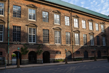 Fototapeta premium Old red brick building wall of house undera rays of sun. City center of Copenhagen, Denmark